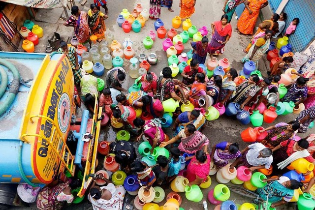 Frauen vor einem Tanklaster, der die Menschen mit Wasser versorgt  | Foto: R. Parthibhan (dpa)