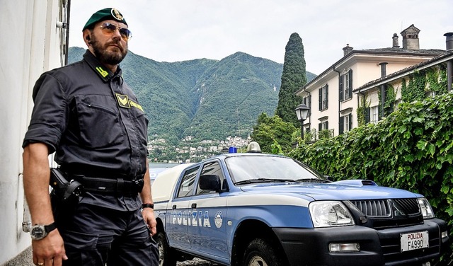 Ein Polizist steht zur Sicherheit vor ...woodstar George Clooney am Comer See.   | Foto: Claudio Furlan (dpa)
