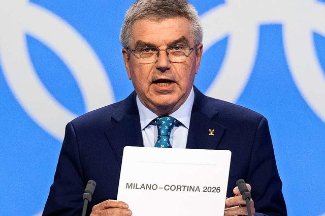 IOC-Prsident Thomas Bach zeigt den Si...richter der Winterspiele 2026: Mailand  | Foto: Laurent Gillieron (dpa)