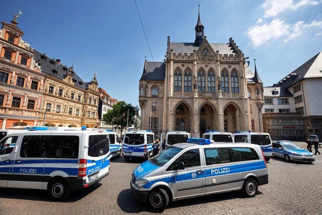 Polizeifahrzeuge stehen nach einer Bombendrohung vor dem evakuierten Rathaus.  | Foto: Michael Reichel (dpa)