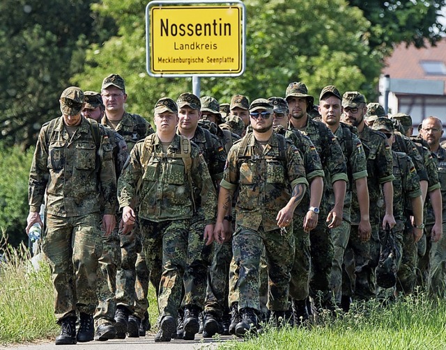 Soldaten marschieren zu ihrer Unterkunft.  | Foto: Daniel Bockwoldt (dpa)