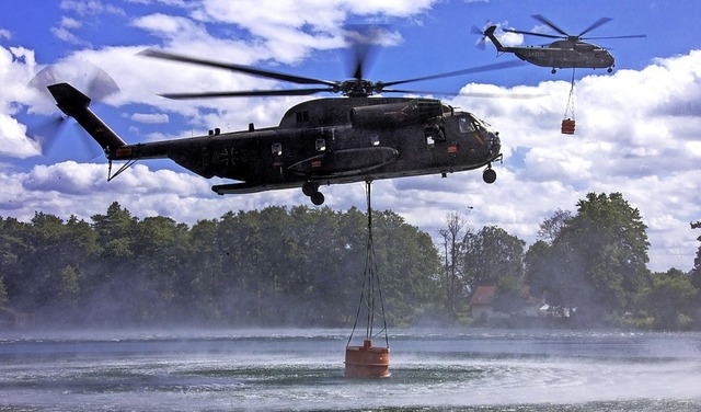 Zwei Hubschrauber der Bundeswehr nehmen Lschwasser auf.  | Foto: Jens Bttner (dpa)