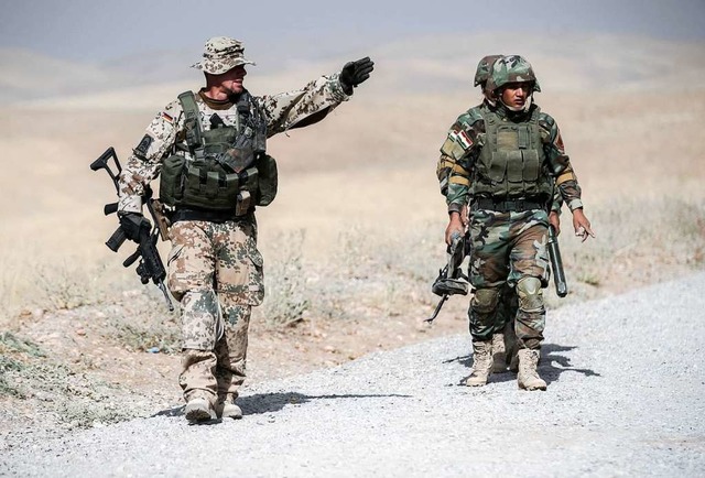 Bundeswehrsoldat und kurdischer Peschm...len, dass sie auch nach Syrien kommen.  | Foto: Michael Kappeler (dpa)
