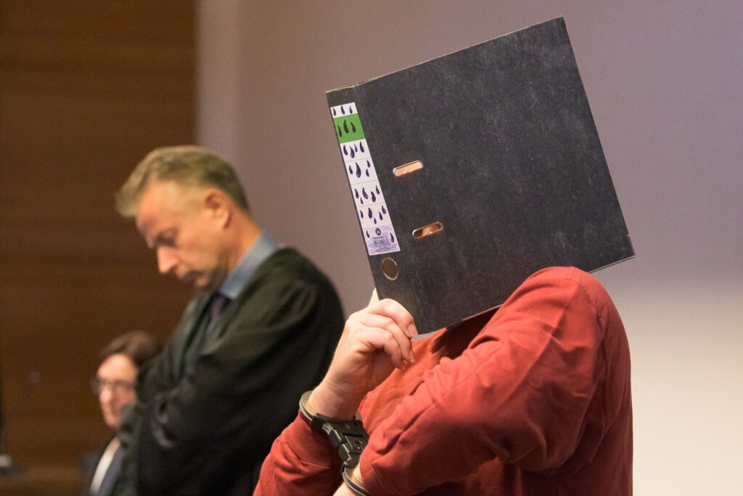 Der 58-jährige Angeklagte (r) steht im Gerichtssaal des Landgerichts.  | Foto: Silas Stein (dpa)
