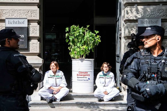 Polizisten stehen vor den Klimaaktivis...izer Bank Credit Suisse demonstrieren.  | Foto: Ennio Leanza (dpa)