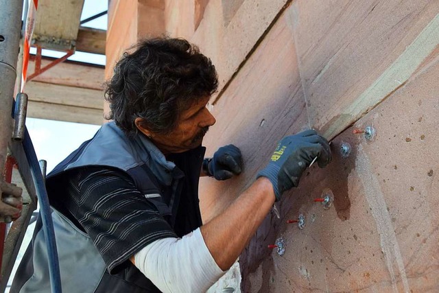 Ein Handwerker bessert kleinere Schads...rtel hinter die Mauersteine gespritzt.  | Foto: Stefan Ammann