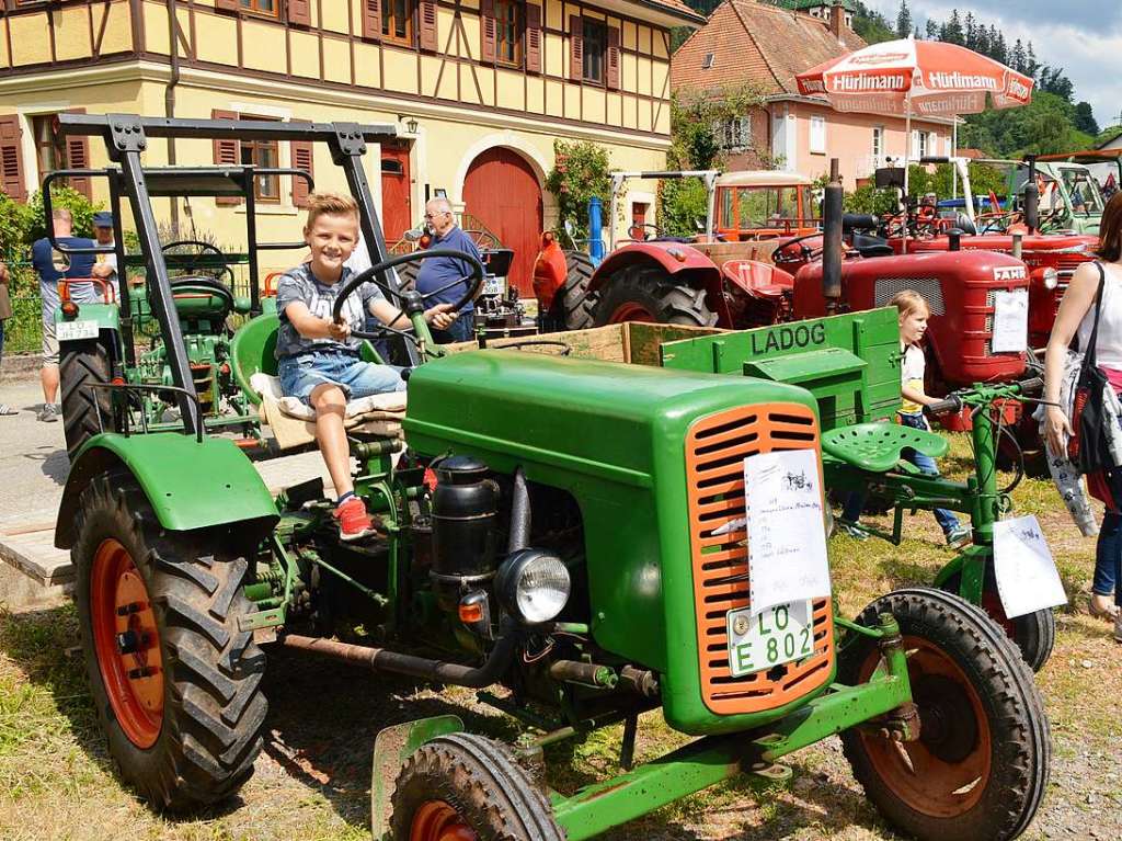 Junger Fahrer auf altem Traktor