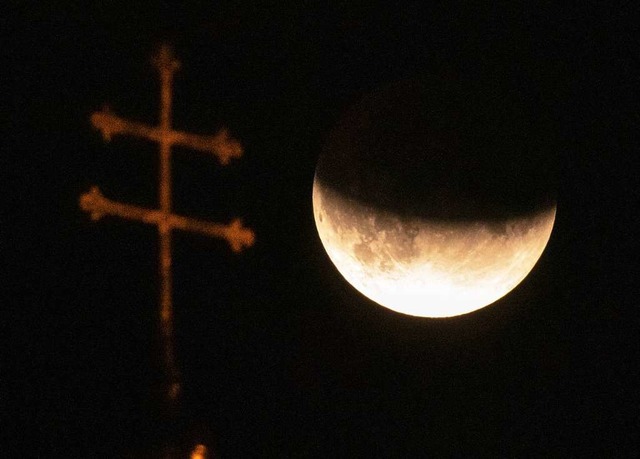 Mnchen:  Der Mond ist whrend einer p...m Dach der Heiliggeistkirche zu sehen.  | Foto: Peter Kneffel (dpa)