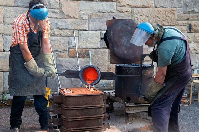 Die auf 1100 Grad erhitzte Bronze wird...lini durch die Einflllcher gegossen.  | Foto: Volker Mnch