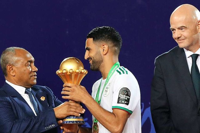 Der Siegtorschtze Riyad Mahrez (Mitte...t von FIFA-Prsident Gianni Infantino.  | Foto: Oliver Weiken (dpa)