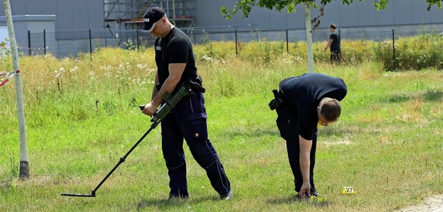 Mit Metalldetektoren suchen Polizisten den Boden nahe dem Fundort der Leiche ab.  | Foto: Ingo Schneider