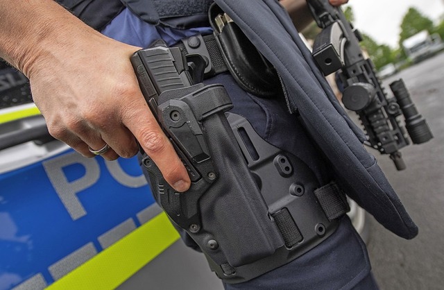 Der Polizist hat bei einer bung seine Hand an der Pistole.  | Foto: Boris Roessler (dpa)