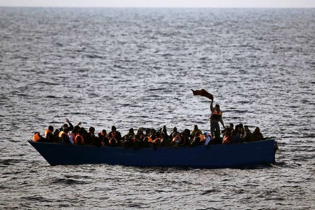 Flchtlinge aus Afrika rufen auf dem Mittelmeer in einem Boot um Hilfe.  | Foto: Emilio Morenatti (dpa)