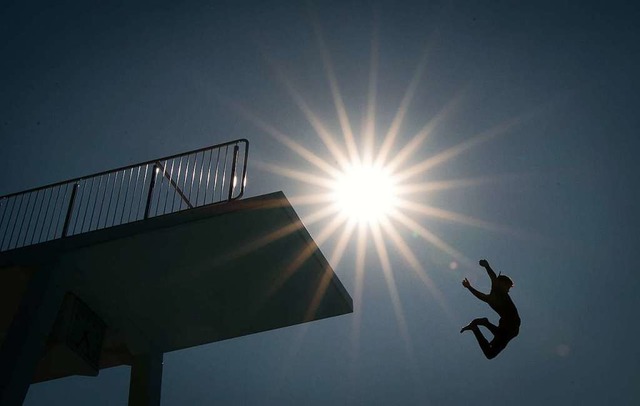 Ein Badegast springt vom 10-Meter-Turm in einem Freibad.   | Foto: Friso Gentsch (dpa)