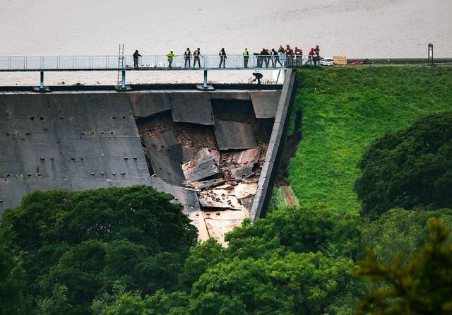 Menschen bilden ber dem beschdigter ...Ortschaft in der Nhe wurde evakuiert.  | Foto: Danny Lawson (dpa)