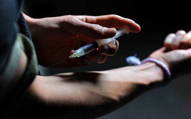 Ein Man hlt eine Heroinspritze an seinen Arm.  | Foto: Frank Leonhardt