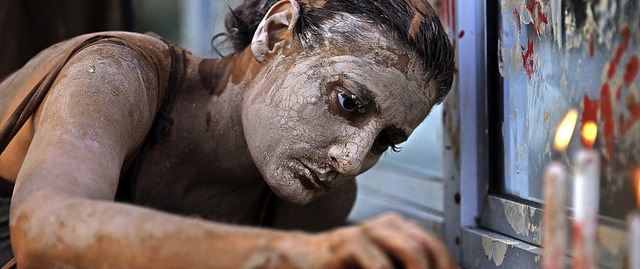 Eine Demonstrantin erinnert mit  Kerzen an den Dammbruch in Brasilien.   | Foto: Fabio Teixeira