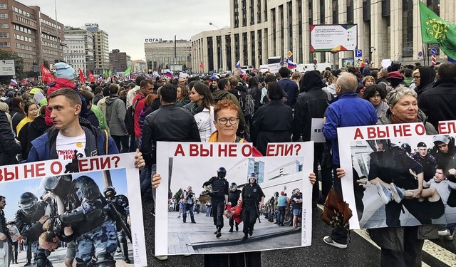 Diese Plakate bei der Grodemonstration in Moskau prangern Polizeigewalt an.   | Foto: Ulf Mauder (dpa)