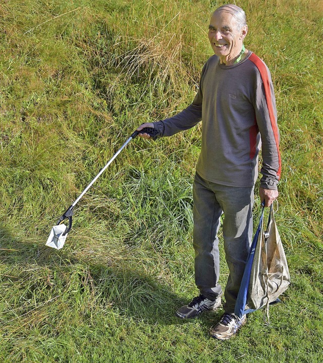 Paul Kreusel hebt im Kurgarten den Mll mit seiner Greifzange  auf.  | Foto: Nora Bulla