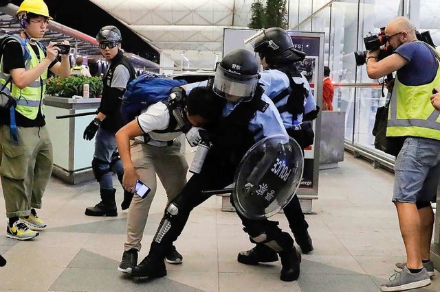 Polizisten gehen gegen Demonstranten in Hongkong vor.  | Foto: Kin Cheung (dpa)