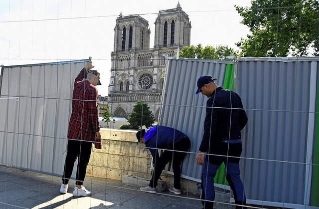 Arbeiter errichten einen Bauzaun um die Kirche.  | Foto: BERTRAND GUAY (AFP)