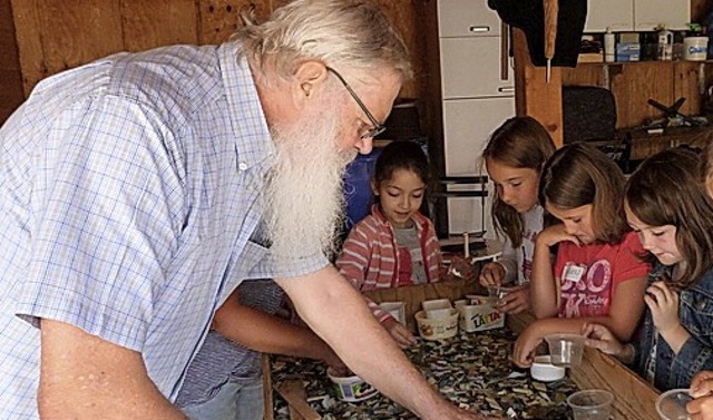 Knstler Wolfgang Frse sucht beim Mos...den Kindern passende Glasscherben aus.  | Foto: suedkurier
