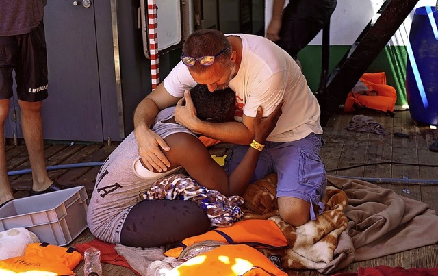 Ein Besatzungsmitglied des spanischen ...ms trstet am Sonntag einen Migranten.  | Foto: Francisco Gentico (dpa)