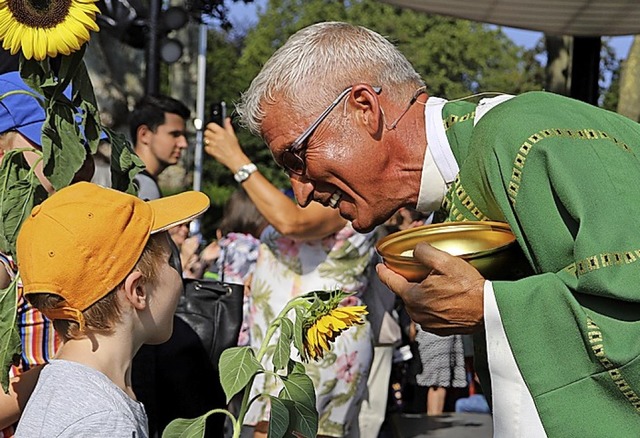 Pfarrer Thomas Ehret spricht bei der Kommunion mit einem Kind.  | Foto: Bonifatiuswerk