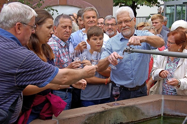 Gratiswein fliet zum Festauftakt aus dem Dorfbrunnen.  | Foto: Christian Ringwald