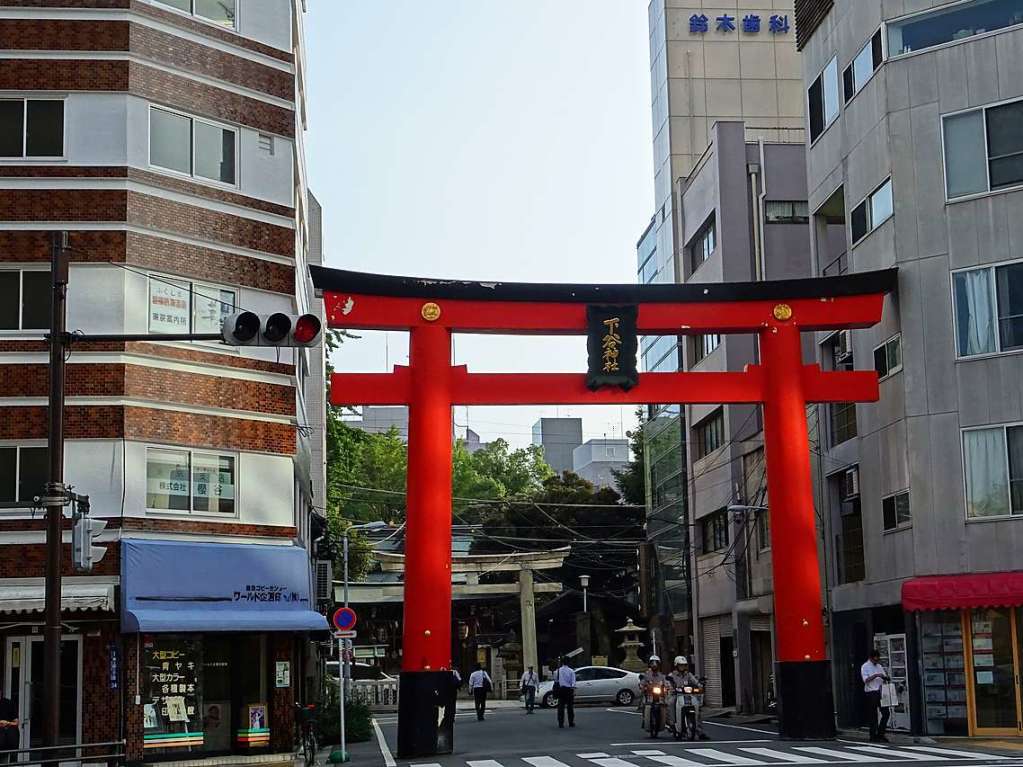 Tokyo: Moderne und Tradition im Stadtteil Ueno, Tokyo. Das rote Torii-Tor zeigt an, dass dahinter ein kleiner Shinto-Schrein liegt, der Shitaya-Schrein.