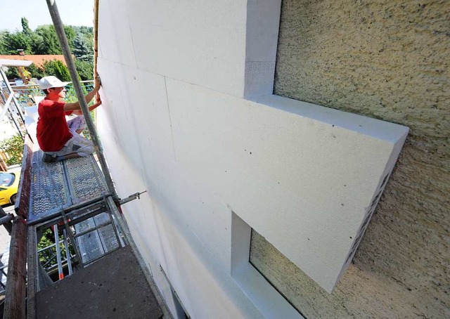 Ein Arbeiter dmmt eine Hausfassade.  | Foto: Armin Weigel