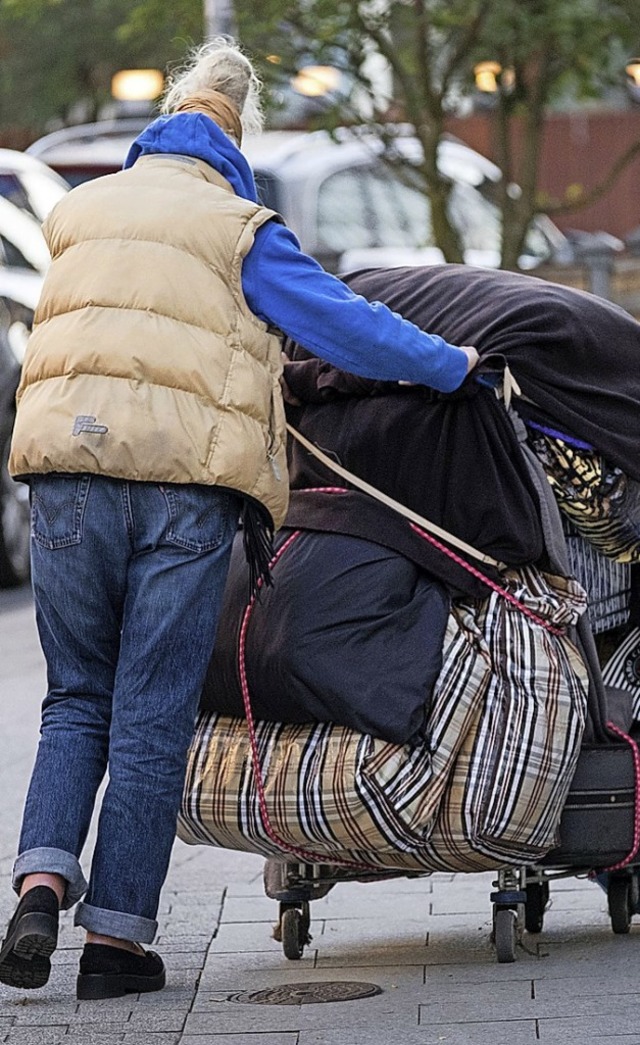 Eine Obdachlose schiebt ihre Habseligkeiten vor sich her.  | Foto: Peter Steffen