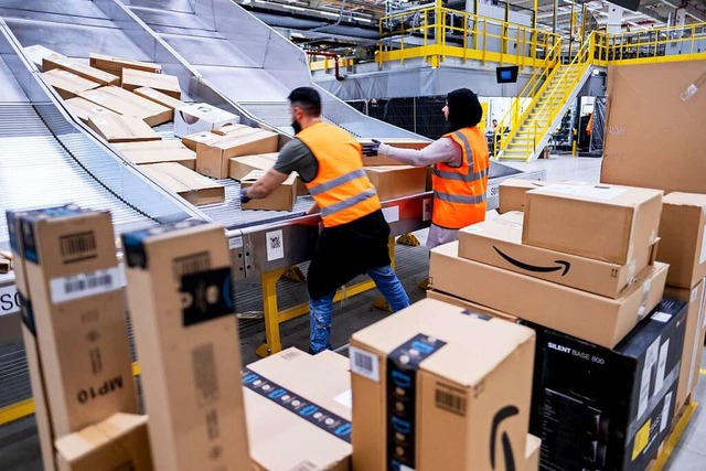 Mitarbeiter von Amazon sortieren Paket...tierzentrum in Garbsen, Niedersachsen.  | Foto: Peter Steffen (dpa)