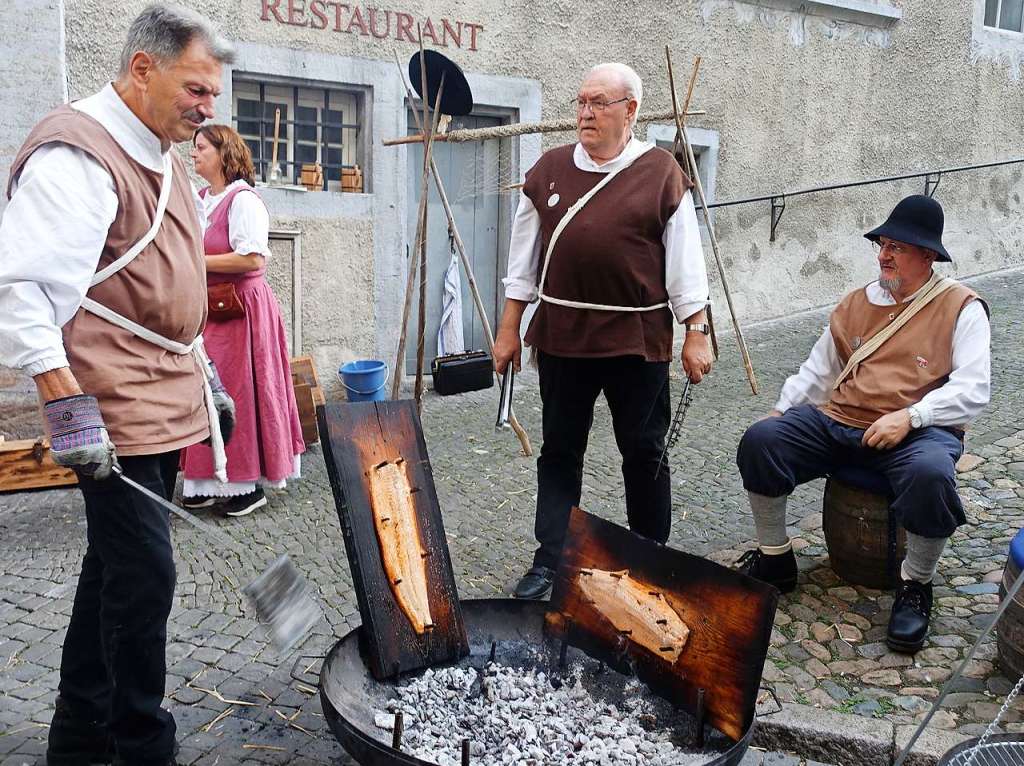 Die Salmfnger in historischen Kostmen bereiteten den Lachs wie frher mit Holzkohle zu.