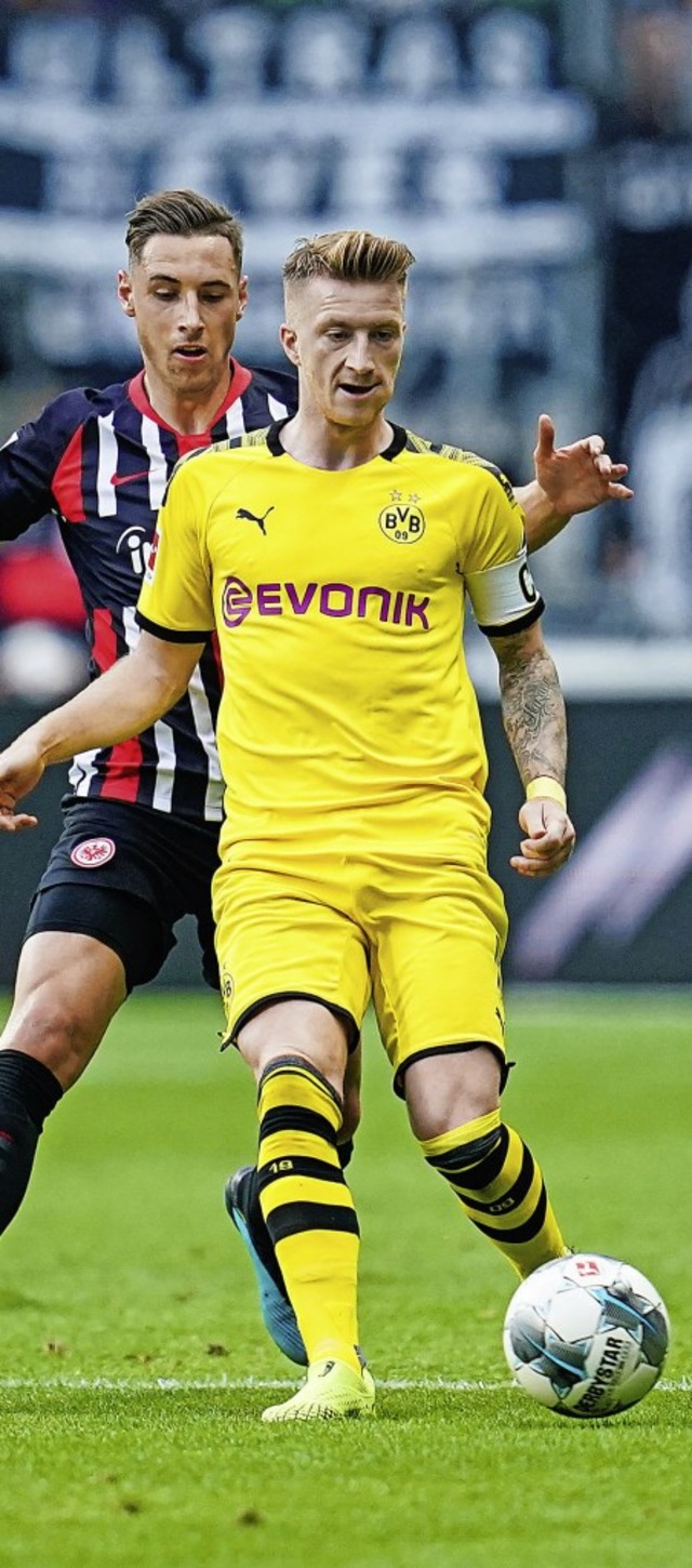 Der Dortmunder  Kapitn Marco Reus wir...racht-Mittelfeldspieler Dominik Kohr.   | Foto: Uwe Anspach (dpa)