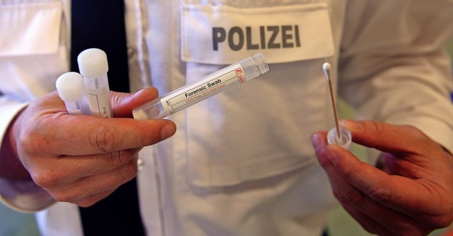 Ein Polizist bei einem Massengentest &...unkelhutige zum Massengentest bitten.  | Foto: Axel Heimken