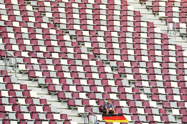 Ein Zuschauer sitzt alleine mit einer ...ionalflagge auf der Zuschauertribne.   | Foto: Nariman El-Mofty (dpa)