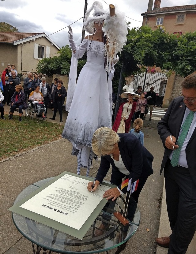 Untersttzt von einer Stelzenluferin ...ig Buhard die Partnerschaftsurkunde.   | Foto: Rainer Glaser