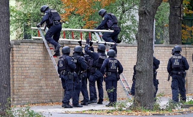 Polizisten mit Schutzhelmen bersteige... Mauer am jdischen Friedhof in Halle.  | Foto: Sebastian Willnow (dpa)