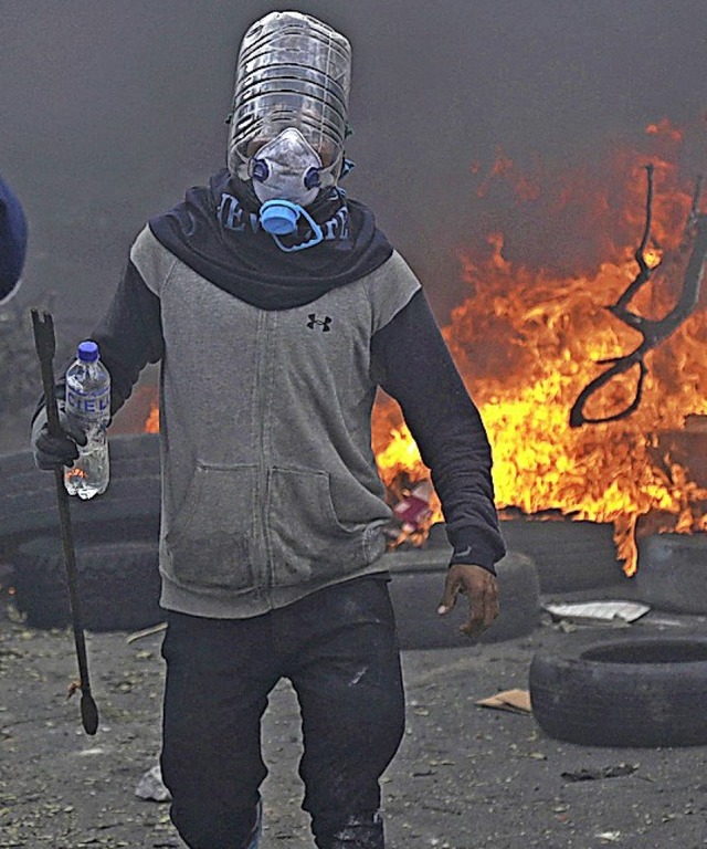 Aufruhr in Quito: Ein Demonstrant hat ... selbstgebauten Gasmaske ausgerstet.   | Foto: Dolores Ochoa (dpa)