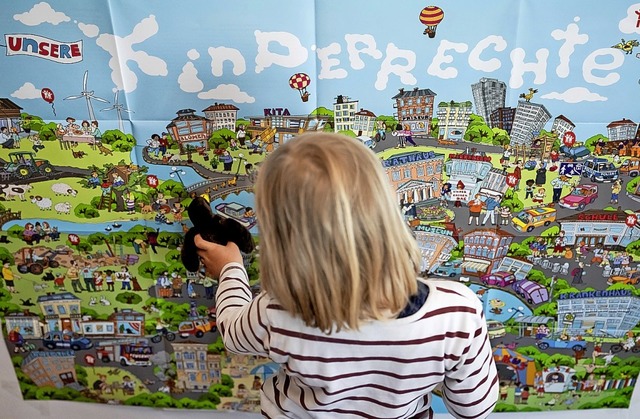 Ein Kind vor einem groen Poster zu Kinderrechten  | Foto: Christoph Soeder (dpa)