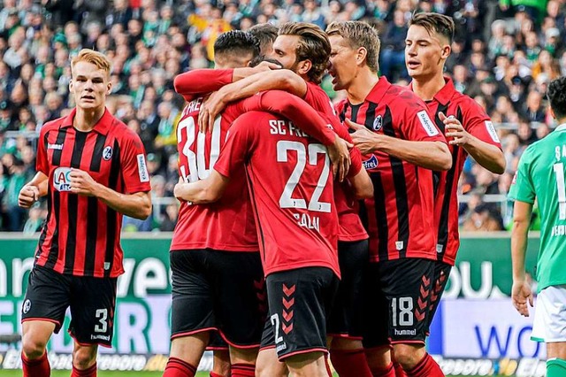 Die Freiburger Spieler bejubeln einen Treffer.  | Foto: Axel Heimken (dpa)