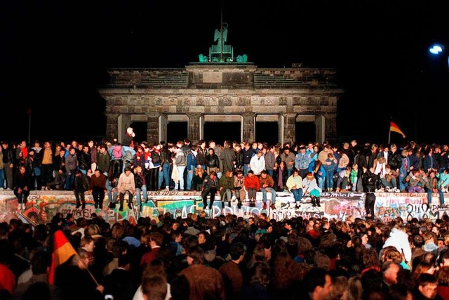 Jubelnde Menschen auf der Berliner Mauer am Brandenburger Tor (Archivfoto)  | Foto: Wolfgang Kumm (dpa)