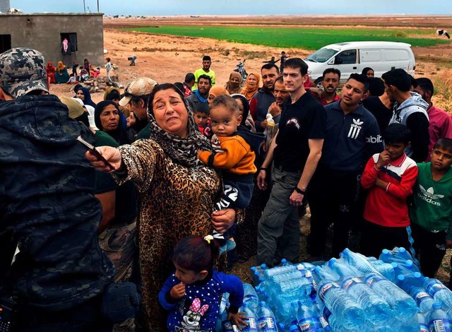 Menschen, die vor dem Einmarsch der t...nd, werden mit Lebensmitteln versorgt.  | Foto: Carol Guzy (dpa)