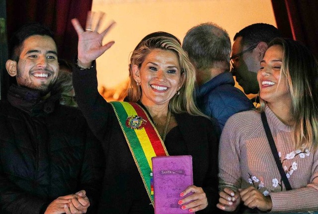 Boliviens Senatorin Jeanine Anez (Mitt...mado-Palastes winkend zu den Menschen.  | Foto: Juan Karita (dpa)