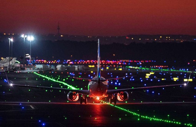 Ein Passagierflugzeug rollt im letzten...onne ber die Rollbahn des Flughafens.  | Foto: Boris Roessler (dpa)