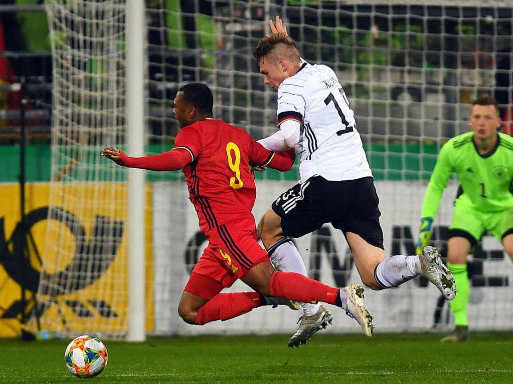 Luca Kilian (Mitte) von Deutschland in Aktion gegen Lois Openda von Belgien, dahinter Torwart Markus Schubert (rechts) von Deutschland.