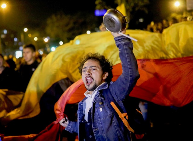 Ein junger Mann nimmt an einem Protest teil.  | Foto: Ivan Valencia (dpa)