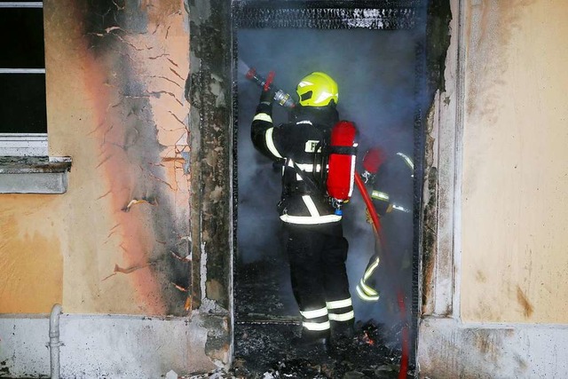 Ein Feuerwehrmann im Inneren des brenn...er Stadtverwaltung untergebracht sind.  | Foto: Stefan Rampfel (dpa)
