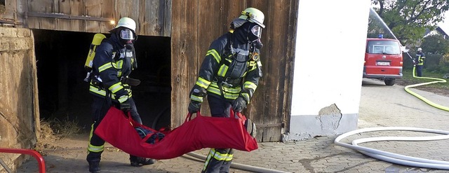 Die Atemschutztrger der Feuerwehrabte... Personen aus der verqualmten Scheune.  | Foto: suedkurier
